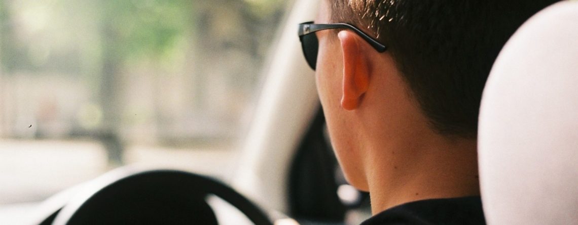 Man Driving Car Wearing Black Sunglasses and Shirt